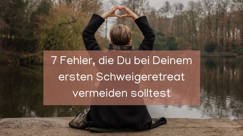 sitzende Frau am See, mit Händen über den Kopf, die zu einem Herz geformt sind