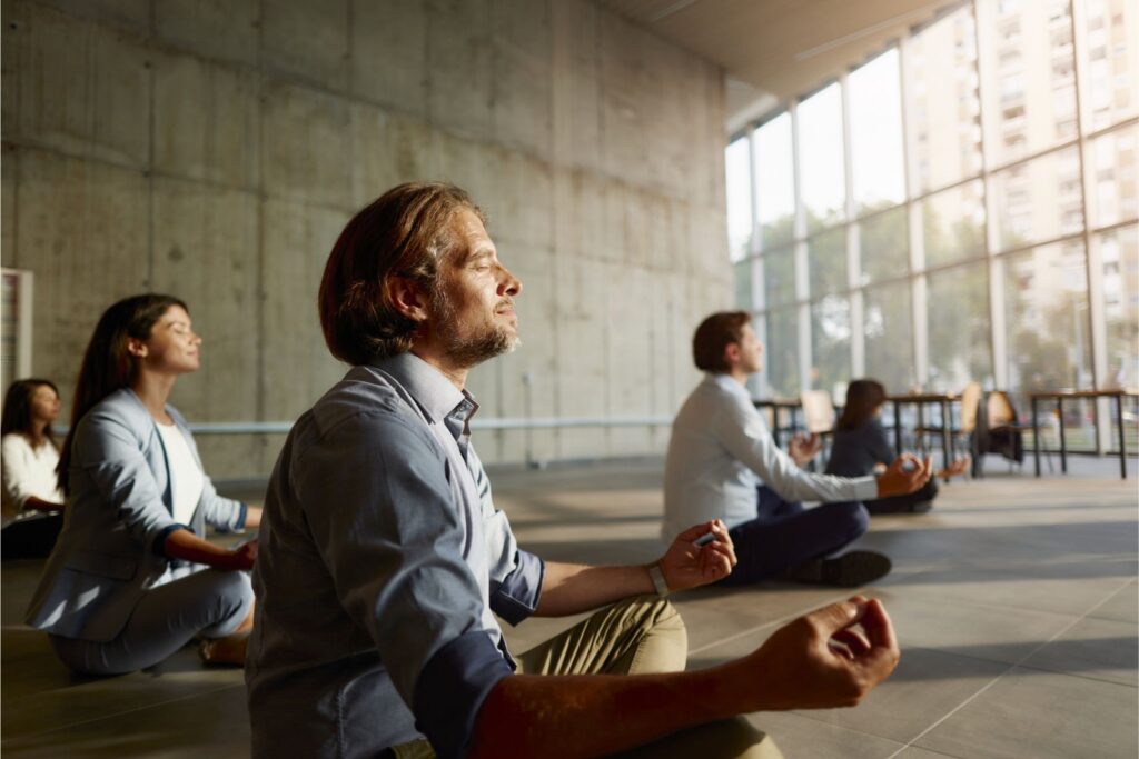 Erwachsene meditieren im Unternehmen